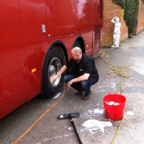 Richard pretending to clean the bus wheels on a One Direction tour.